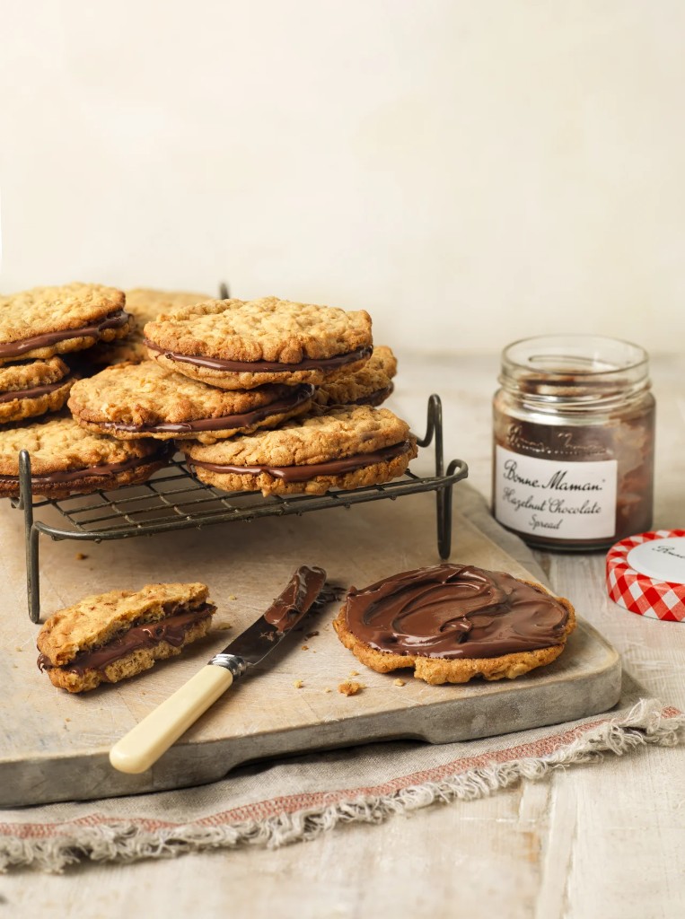 Oatmeal sandwich cookies with chocolate hazelnut spread and open jar